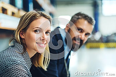 A portrait of an industrial man and woman engineer in a factory, looking at camera. Stock Photo