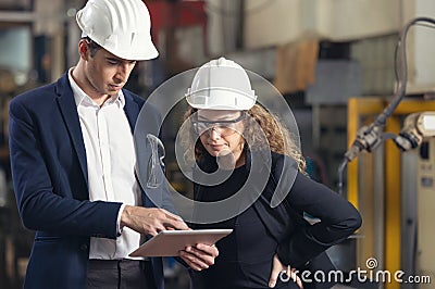 A portrait of an industrial man and woman engineer with tablet in a factory, working Stock Photo