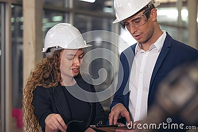 A portrait of an industrial man and woman engineer with tablet in a factory, working Stock Photo
