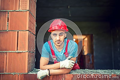 Portrait of industrial worker on construction site, sitting and relaxing after a hard day at work. Brick mason worker Stock Photo