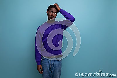 portrait inspired by the idea of a dark-skinned american young guy in a blue sweatshirt and jeans in the studio Stock Photo