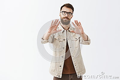 Portrait of intense bothered and displeased guy asking slow down or keep distance between him pulling palms in defence Stock Photo