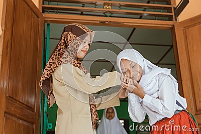 Portrait of islamic school students kissing the teacher`s hand Stock Photo