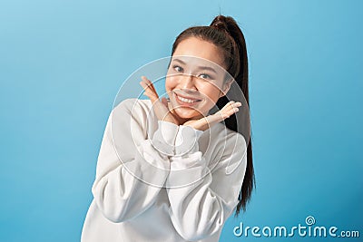 Portrait of joyful carefree adorable adult woman smiling broadly and holding palms near cheeks, being playful and emotive with Stock Photo