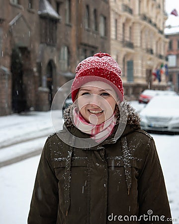 Portrait joyful young woman with blond hair having fun on street full with snow Stock Photo
