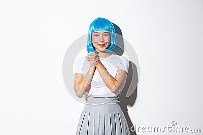 Portrait of kawaii asian girl looking grateful and amused, clasp hands together and smiling pleased at camera, standing Stock Photo