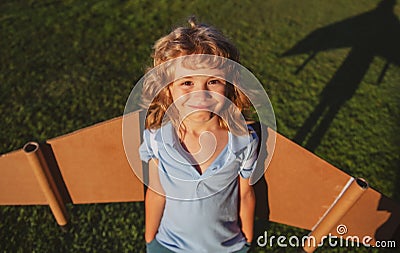 Portrait of kid with backpack wings. Child playing pilot aviator and dreams outdoors in park. Smiling kid dreaming about Stock Photo