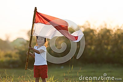 Kids raising indonesian flag Stock Photo