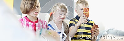 Kids sitting on couch and playing card game collectively Stock Photo