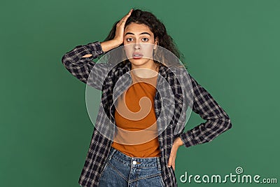 Portrait of Latino beautiful girl isolated on green, vintage color studio background. Concept of human emotions, facial Stock Photo