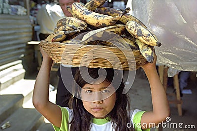 Portrait of Latino girl with bananas, child labor Editorial Stock Photo