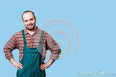 portrait of a laughing bearded young workman with arms on hips is the epitome of positivity. Stock Photo