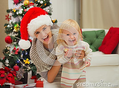 Portrait of laughing mother and eat smeared baby Stock Photo