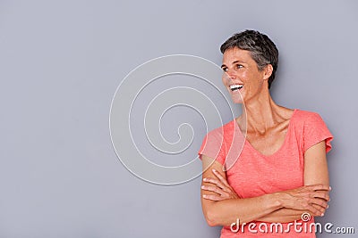 Laughing older woman against gray wall Stock Photo