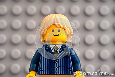 Portrait of Lego blond businessman minifigure against Lego gray baseplate Editorial Stock Photo