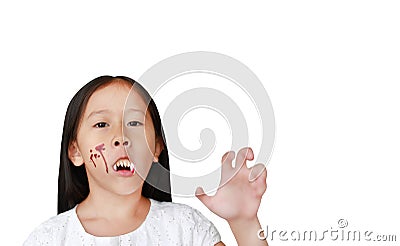 Portrait of little Asian child girl with face make up in Halloween costume looking at camera with frightening expression over Stock Photo