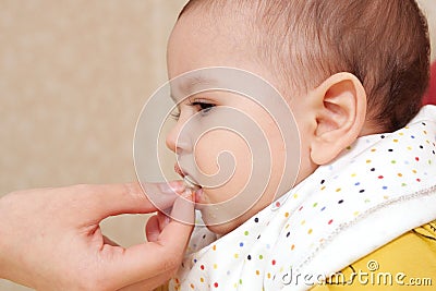 Portrait of little baby boy eating food. Baby with a spoon in feeding chair. Cute baby eating first meal Stock Photo