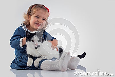 Portrait of Little baby girl holding her fluffy cat on white background Stock Photo