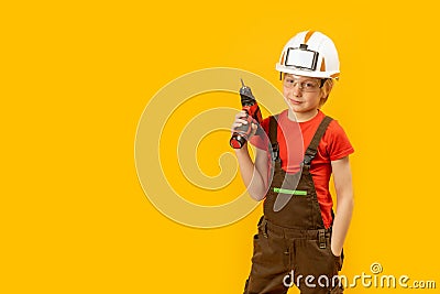 Portrait of little boy pretends to drill wall with drill, yellow isolated background. Boy teenager as builder worker. Copy space, Stock Photo