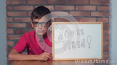 Child sitting at the desk holding flipchart with lettering fired Stock Photo