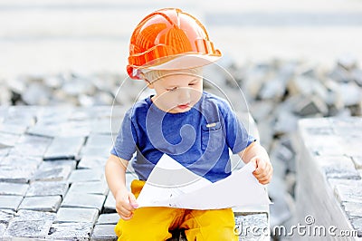 Portrait of little builder in hardhats reading construction drawing Stock Photo