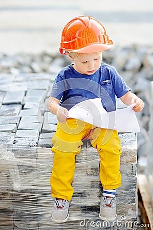 Portrait of little builder in hardhats reading construction drawing Stock Photo
