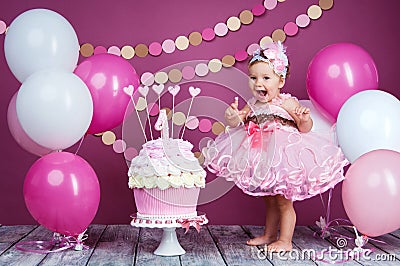 Portrait of a little cheerful birthday girl with the first cake. Eating the first cake. Smash cake Stock Photo