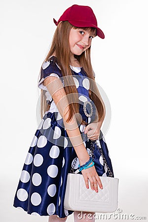 Portrait of little cheerful girl in a polka dot dress and red cap Stock Photo