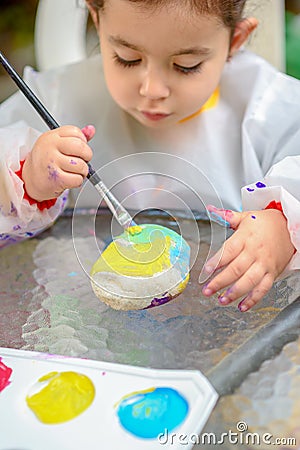 Little Girl Drawing On Stone Outdoors In Summer Sunny Day. Stock Photo