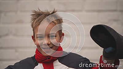 Portrait of little cute boy in jacket with red collar with baby cap in hand Stock Photo