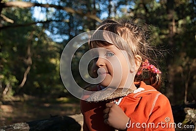 Portrait of a little five-years-old girl holding a parasol mushroom. Stock Photo