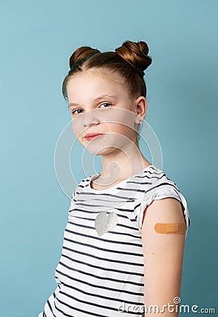 Portrait little girl with adhesive plaster on shoulder posing isolated. Covid-19 prevention Stock Photo
