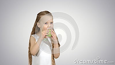 Portrait of a little girl eating green apple on white background Stock Photo