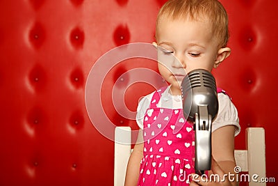 Portrait of little girl with microphone on rack Stock Photo