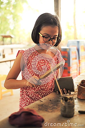 Portrait little girl molds the clay for producing the pottery work in workshop class Stock Photo