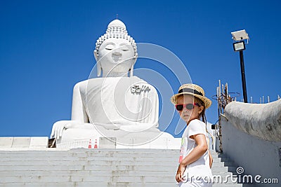 Portrait of little girl standing near Big Buddha statue in Phuket, Thailand. Concept of tourism in Asia and famous Stock Photo