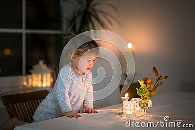 Portrait of little girl watching candles in dark room Stock Photo