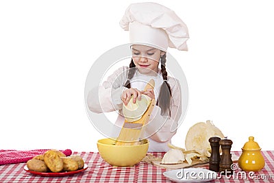 Portrait of a little girl in a white apron and chefs hat shred c Stock Photo