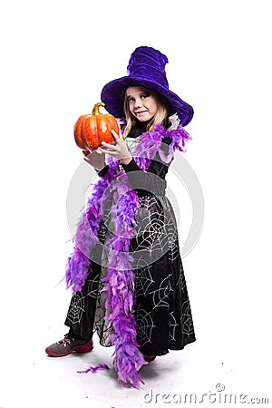 Portrait of little girl in witch costume with pumpkin. Halloween character Stock Photo