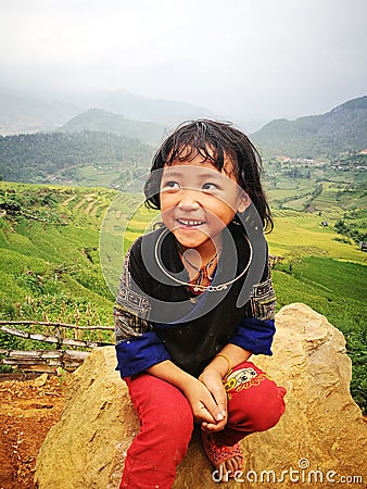 Portrait of a little Hmong (Miao) minority girl sitting on a rock Editorial Stock Photo