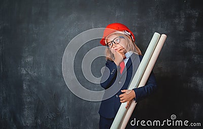 Portrait of little kid in safety helmet and suit thinking about aspirations. Little businessman in glasses looking up Stock Photo