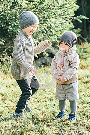 portrait of little preschool brother trying to cheer up shy toddler sister Stock Photo