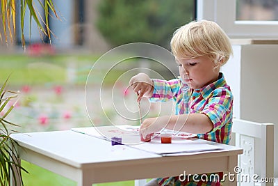 Portrait of little toddler girl painting with brush Stock Photo