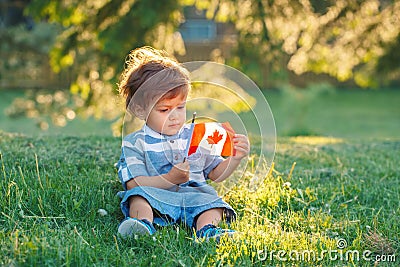 Caucasian baby boy holding Canadian flag with red maple leaf Stock Photo