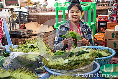 Yangon, Myanmar - December 31 2019: A local woman sells paan chewing tobacco with betel vine leaves and areca nut Editorial Stock Photo