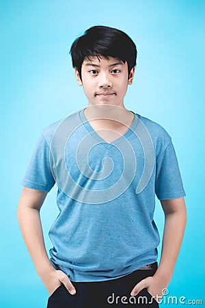 Portrait of look good asian kid boy on blue background Stock Photo