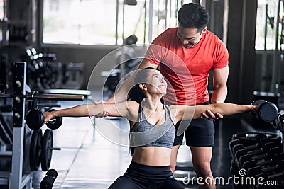 Fitness couple train with Dumbbells in gym Stock Photo