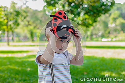 Portrait lovely little boy in the park. Attractive handsome young boy is putting the mask for playing in garden in evening. Lovely Stock Photo