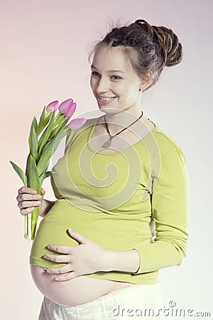 Portrait of lovely smiling pregnant woman with tulips Stock Photo