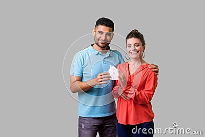 Portrait of lucky young couple in casual clothes satisfied with home purchase, mortgage. isolated on gray background Stock Photo